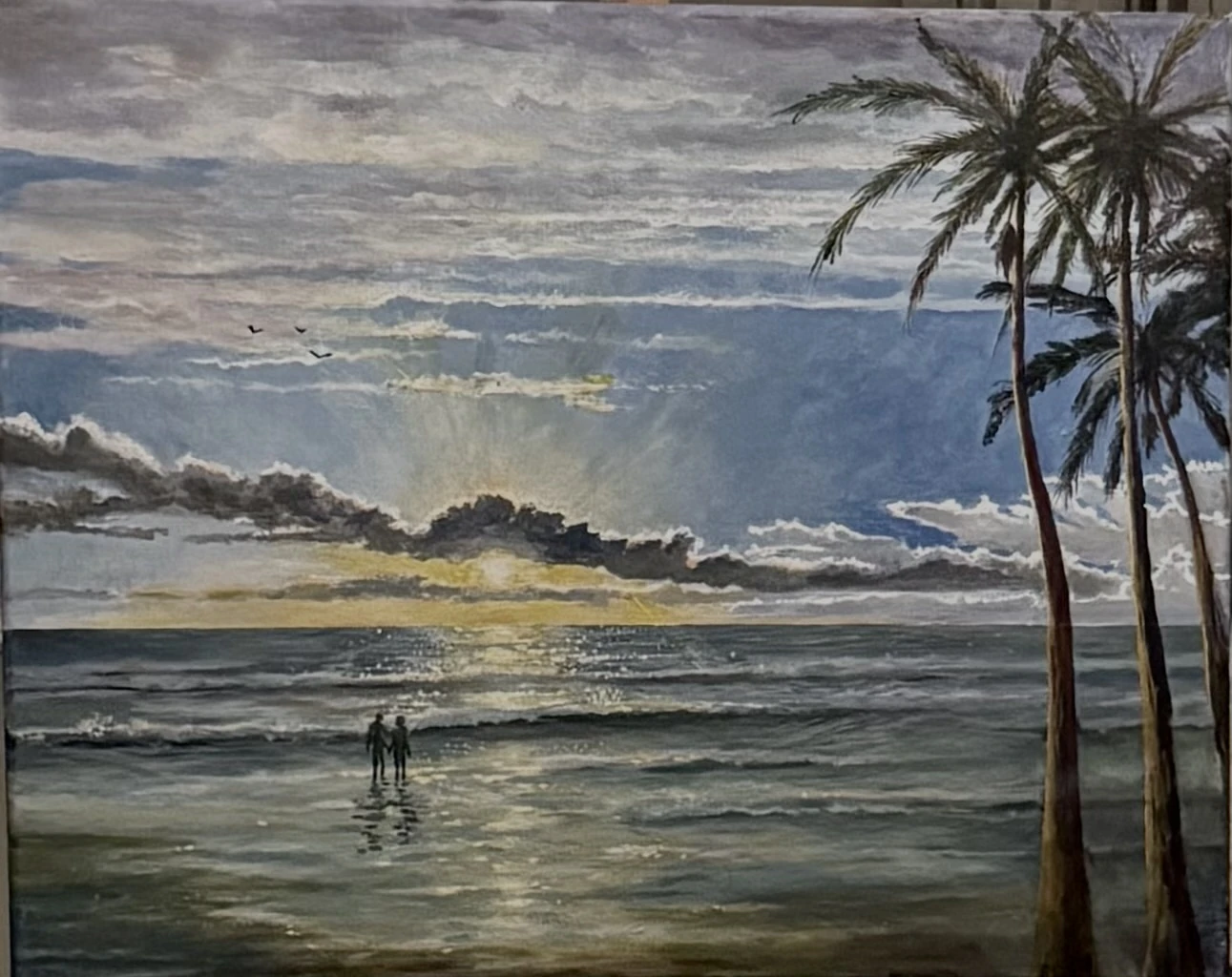 Acrylic painting of two silhouetted figures standing in shallow surf at sunset with sun rays and palm trees